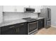 Kitchen with stainless appliances, dark lower cabinets, white upper cabinets and gray counter-tops at 200 Bucksley Ln # 302, Charleston, SC 29492