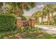 Street view of the property's brick sign with lush flower beds, palm trees, and greenery at 200 Bucksley Ln # 302, Charleston, SC 29492