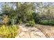 Stone path winds through the lush, green backyard, creating a serene outdoor space at 2137 Wappoo Dr, Charleston, SC 29412
