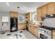 Functional kitchen with light wood cabinets, stainless steel appliances, and black-and-white tiled floor at 2137 Wappoo Dr, Charleston, SC 29412