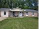Charming single-story brick home with a well-maintained lawn and inviting front porch seating area at 225 Arbor Rd, Summerville, SC 29485