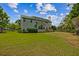 Expansive backyard with lush lawn and mature trees with a view of the back of the house and wooden deck at 2524 Deer Walk Way, Mount Pleasant, SC 29466
