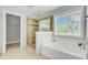 Bright bathroom featuring a large tub, glass-enclosed shower, and a window bringing in natural light at 2524 Deer Walk Way, Mount Pleasant, SC 29466