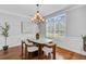Bright dining room with wood floors, a stylish chandelier, and a large window with plantation shutters at 2524 Deer Walk Way, Mount Pleasant, SC 29466