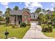 Beautiful home featuring a brick facade, attached garage, and large front lawn with mature landscaping at 2524 Deer Walk Way, Mount Pleasant, SC 29466