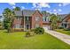 Charming two-story brick home featuring lush landscaping and an attached garage at 2524 Deer Walk Way, Mount Pleasant, SC 29466