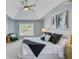 Bright main bedroom featuring a tray ceiling, ceiling fan, and a comfortable seating area by the window at 2524 Deer Walk Way, Mount Pleasant, SC 29466
