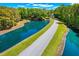 Aerial view of a picturesque community featuring a beautiful pond, tree coverage, and lush lawns at 2828 Olivia Marie Ln, Johns Island, SC 29455