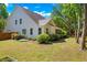 Beautifully landscaped backyard with lush lawn, mature trees, and charming white exterior of the house at 2828 Olivia Marie Ln, Johns Island, SC 29455