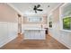 Cozy dining area featuring custom wainscoting, hardwood floors, designer fan, and natural light streaming through the windows at 2828 Olivia Marie Ln, Johns Island, SC 29455