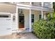Inviting front entryway with a wood door, stylish lanterns, brick walkway, and lush landscaping for added curb appeal at 2828 Olivia Marie Ln, Johns Island, SC 29455