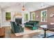 Cozy living room with a fireplace, bright windows, wood paneled ceilings, and comfortable furnishings at 2828 Olivia Marie Ln, Johns Island, SC 29455