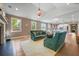 Spacious living room showcases a fireplace, large windows, and an open design connecting to the kitchen at 2828 Olivia Marie Ln, Johns Island, SC 29455