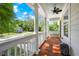 Inviting covered front porch with white columns and wood flooring offers serene views of the neighborhood at 2828 Olivia Marie Ln, Johns Island, SC 29455