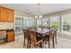 Sunlit dining area with a large table, eight chairs and many windows overlooking backyard at 3500 Maplewood Ln, Mount Pleasant, SC 29466
