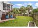 Picture of the home's backyard featuring mature palm trees, a spacious lawn, and privacy fencing at 3526 Stockton Dr, Mount Pleasant, SC 29466