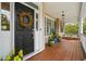 Inviting front porch with wood floors, swing, and decorative wreath on front door at 3526 Stockton Dr, Mount Pleasant, SC 29466