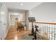 Upstairs hallway with hardwood floors, exercise bike, railing overlooking the lower floor, and a serene seating area at 3526 Stockton Dr, Mount Pleasant, SC 29466