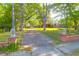 Brick pillars topped with lion statues frame the driveway of a charming brick home at 41 Berkeley Rd, Charleston, SC 29407