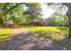 Spacious front yard leads to a charming brick home with mature trees and lush greenery at 41 Berkeley Rd, Charleston, SC 29407