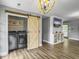 This open laundry room features a sliding barn door, wood plank floors, and updated washer and dryer at 416 Jelly Rolls Rd, Moncks Corner, SC 29461