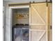 Laundry room featuring modern washer and dryer units and a rustic sliding barn door at 416 Jelly Rolls Rd, Moncks Corner, SC 29461