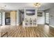 An open living room has built in cabinets with a mounted television, wood plank flooring and green doors at 416 Jelly Rolls Rd, Moncks Corner, SC 29461