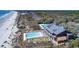 Stunning aerial view of oceanfront pool, with palm trees and a luxury home near the beach at 418 Snowy Egret Ln, Kiawah Island, SC 29455