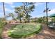The backyard features a putting green and shrubbery with forest backdrop at 418 Snowy Egret Ln, Kiawah Island, SC 29455