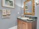 Bathroom vanity with dark wood cabinets, marble countertop, and gold-framed mirror at 418 Snowy Egret Ln, Kiawah Island, SC 29455