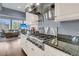 Gourmet kitchen featuring a stainless steel range, granite countertops, and a view into the cozy living area at 418 Snowy Egret Ln, Kiawah Island, SC 29455