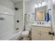 Bright bathroom with a white tiled shower, dark fixtures, and wood-look flooring at 4412 Garwood Dr, Ladson, SC 29456