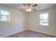 Empty bedroom boasts two big windows, neutral walls, wood-look flooring, and ceiling fan at 4412 Garwood Dr, Ladson, SC 29456