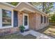 Close up of home entrance featuring brick facade, stylish black shutters and well maintained landscaping at 4412 Garwood Dr, Ladson, SC 29456