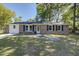 Charming brick home featuring black shutters, manicured lawn and beautiful front yard trees at 4412 Garwood Dr, Ladson, SC 29456