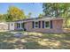 Inviting single-story brick home with black shutters, lush front lawn, and mature trees at 4412 Garwood Dr, Ladson, SC 29456