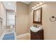 Charming bathroom vanity featuring blue accents, tiled flooring, and a framed mirror at 4952 Steeplechase Ln, Hollywood, SC 29449