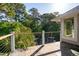 An inviting outdoor deck with wood and a beautiful view of palm trees and green foliage at 4952 Steeplechase Ln, Hollywood, SC 29449