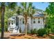 Charming two-story home featuring arched windows, a brick driveway, and mature palm trees at 4952 Steeplechase Ln, Hollywood, SC 29449