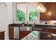 Kitchen sink with stainless steel appliances, custom cabinetry and black countertops at 4952 Steeplechase Ln, Hollywood, SC 29449