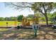 Community playground surrounded by mature trees and grass at 4952 Steeplechase Ln, Hollywood, SC 29449