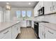 Modern kitchen boasts white cabinets, stainless appliances, hardwood floors, and a peninsula island at 5114 Double Eagle Loop, Summerville, SC 29485