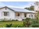 Charming painted brick home with a metal roof, mature landscaping, and inviting porch at 561 Seaward Dr, Charleston, SC 29412