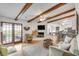 Open living room featuring wood beams, a fireplace, and seamless flow to the kitchen and outdoor spaces at 561 Seaward Dr, Charleston, SC 29412