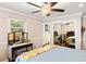 Bright bedroom features hardwood floors, ceiling fan and vanity with mirror at 5907 Murray Dr, Hanahan, SC 29410
