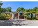 Charming brick home featuring a landscaped yard, gravel driveway, and covered front porch at 5907 Murray Dr, Hanahan, SC 29410