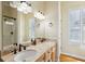 Bright bathroom features double sinks, a large vanity mirror, and shower at 68 W 9Th St # B, Folly Beach, SC 29439