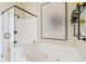 Bathtub features a whirlpool, glass enclosed shower, tile accents, and wall art at 68 W 9Th St # B, Folly Beach, SC 29439