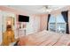 Ensuite bedroom featuring a ceiling fan, mounted television, and sliding doors to a balcony at 68 W 9Th St # B, Folly Beach, SC 29439