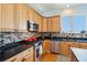 Bright kitchen boasting wooden cabinets, stainless steel appliances, black countertops and colorful backsplash at 68 W 9Th St # B, Folly Beach, SC 29439